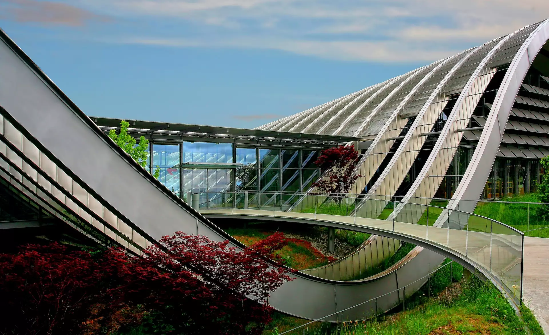 A modern, curved architectural structure with greenery.