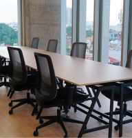 A large meeting room with floor-to-ceiling windows and a long conference table.