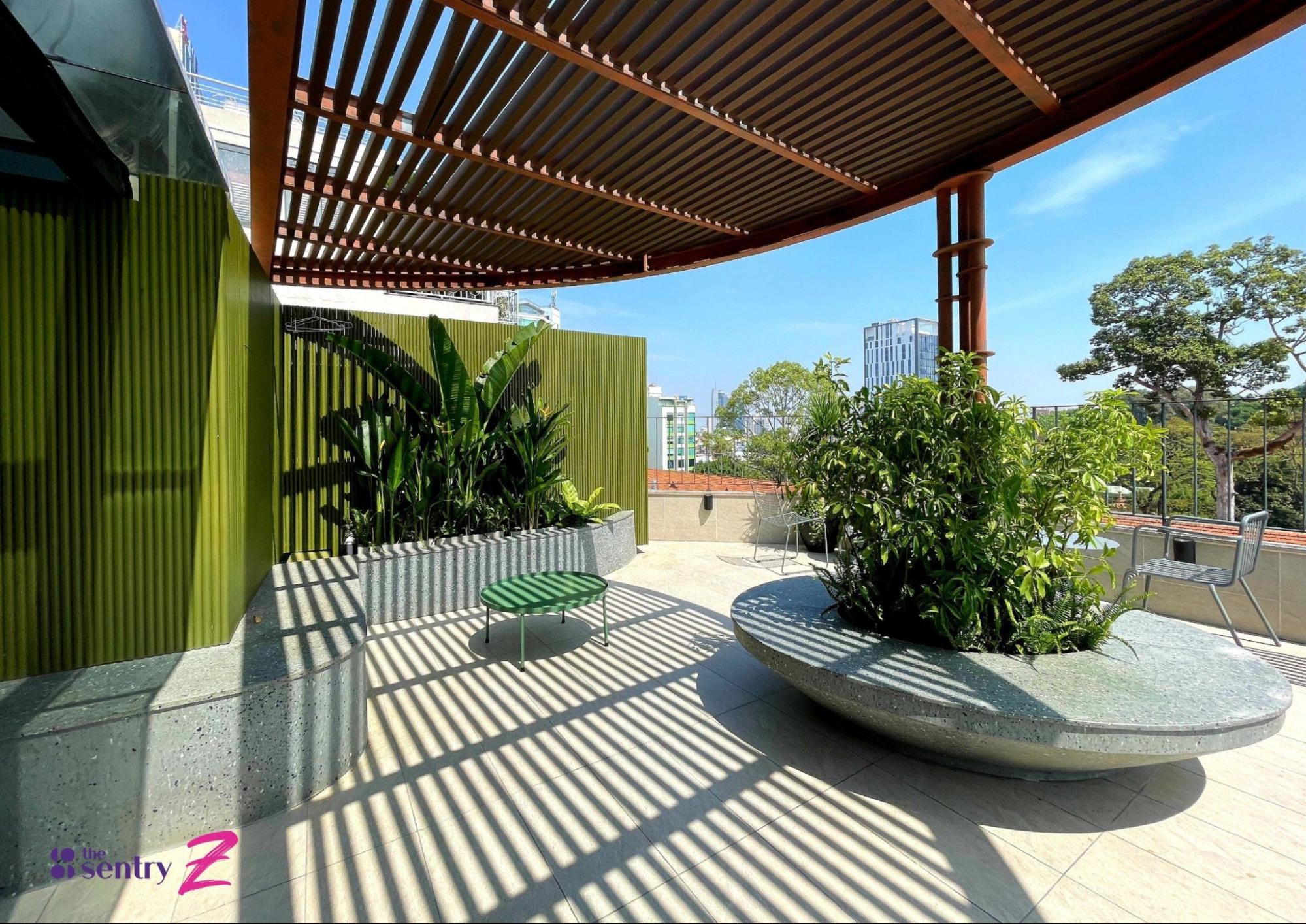 Outdoor coworking area at The Sentry Z with greenery and shaded seating.