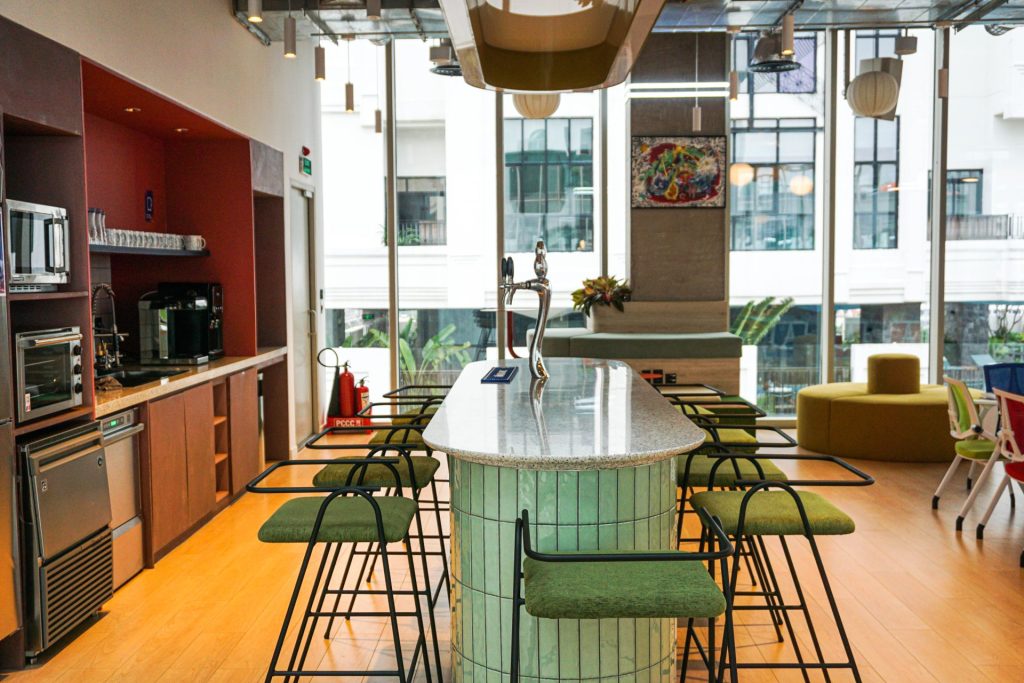 Modern kitchen area with coffee machines and bar seating