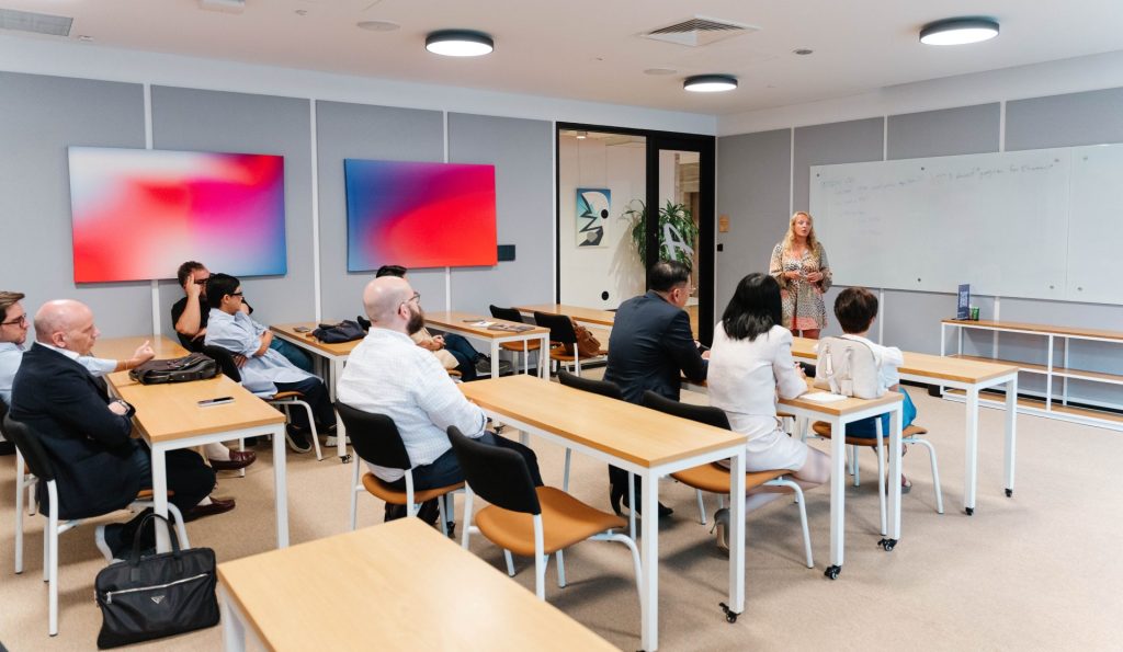 A diverse team collaborating in a modern, glass-walled meeting room.