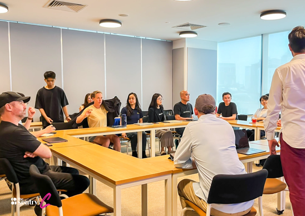 A team having a focused discussion inside a private, glass-walled conference room.