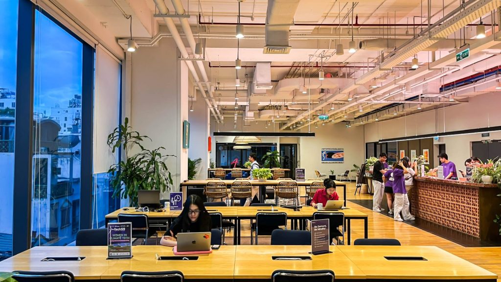 Sunlit open-plan coworking desks with comfortable chairs.