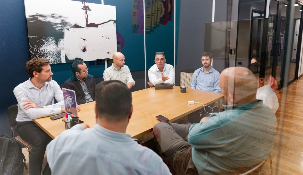 Professionals discussing business in a glass meeting room.