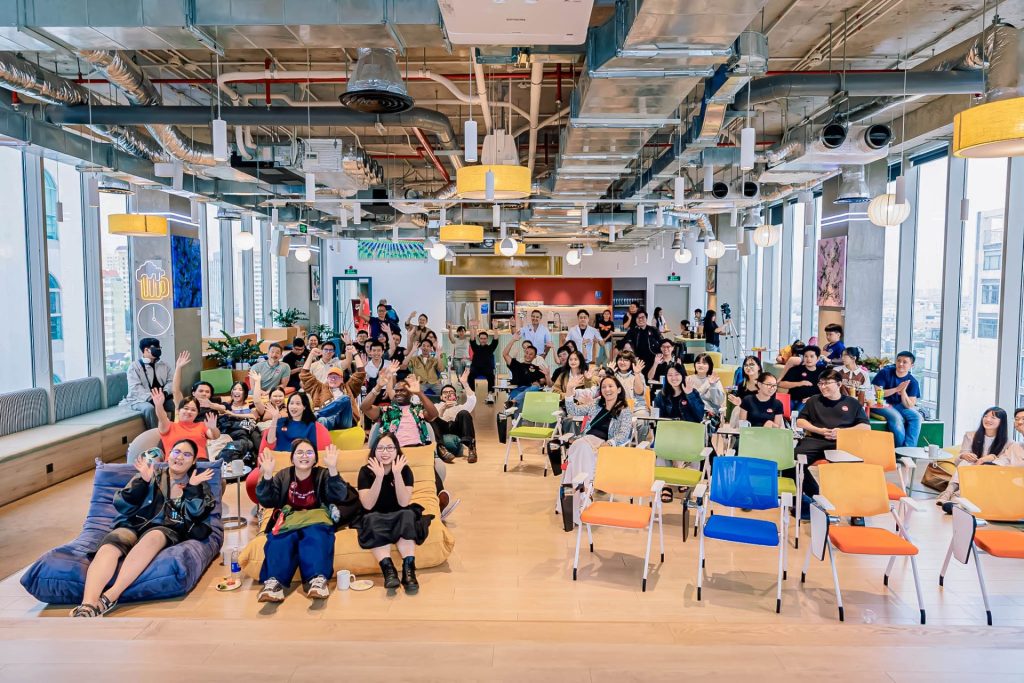  Modern, green coworking event space filled with workshop attendees.