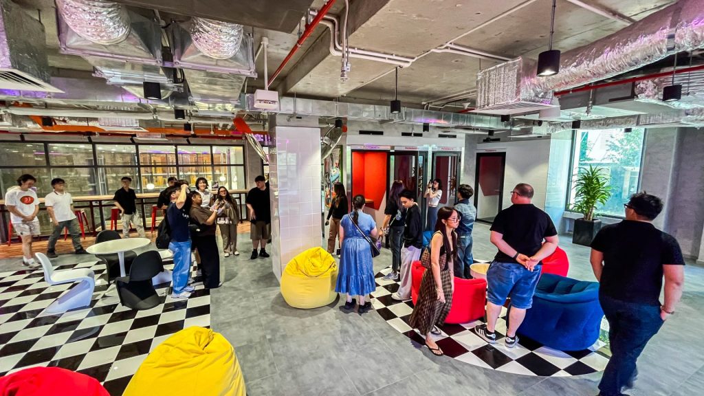 A group of diverse colleagues collaborating around a large communal table or in a breakout area.