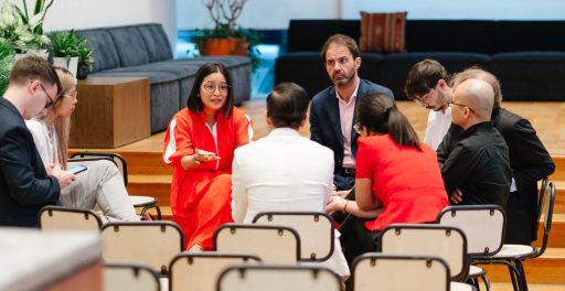 Serious business discussion inside a glass-walled modern meeting room.