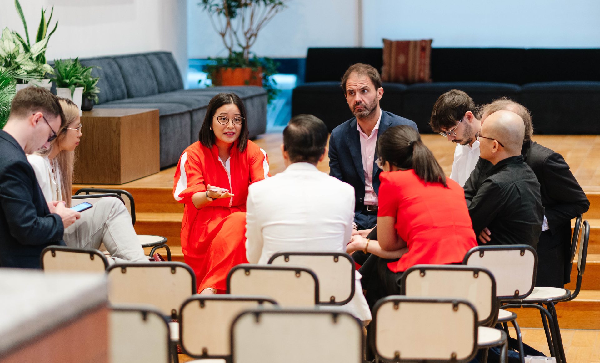 Serious business discussion inside a glass-walled modern meeting room.