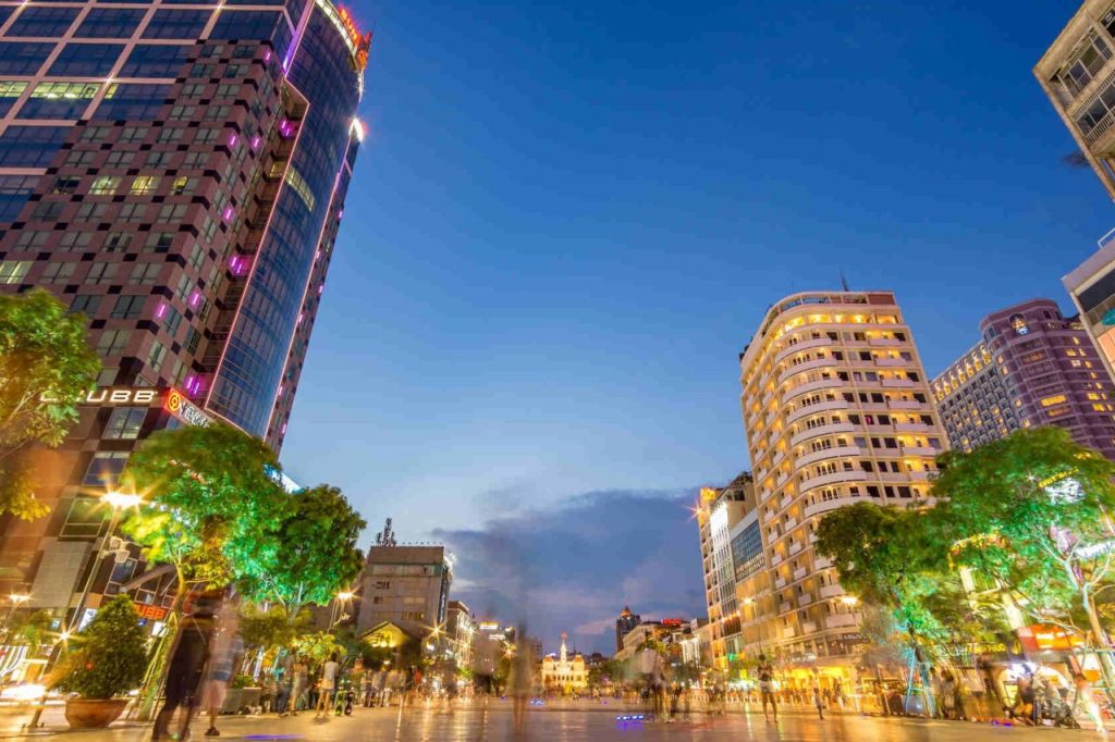 Bustling street scene near Nguyen Hue with bright city lights.