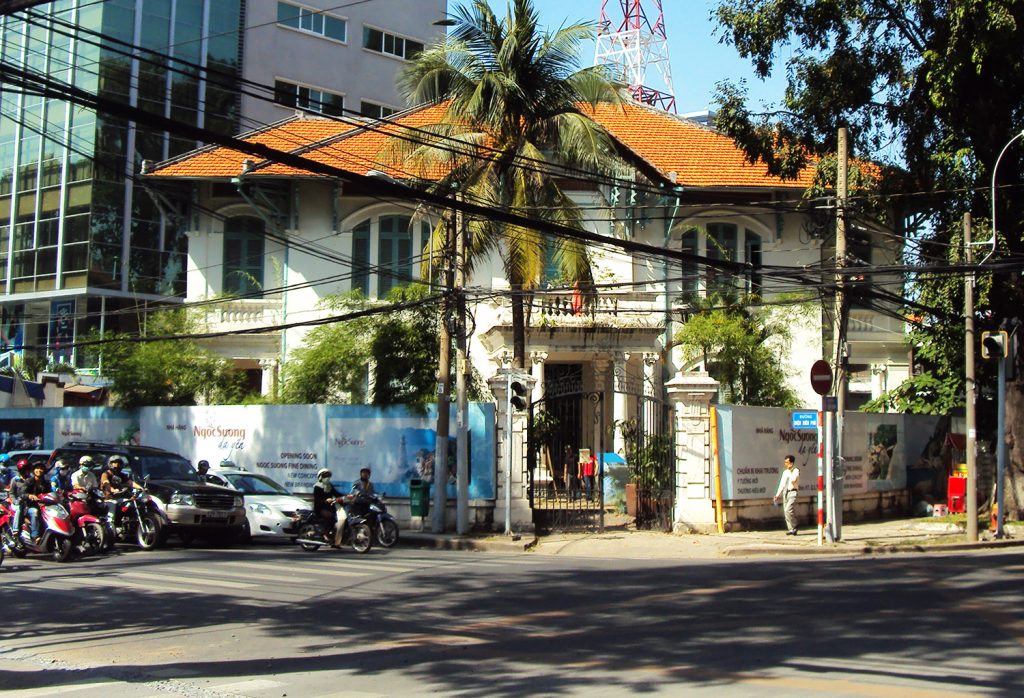  A peaceful, tree-lined street featuring a classic colonial villa.