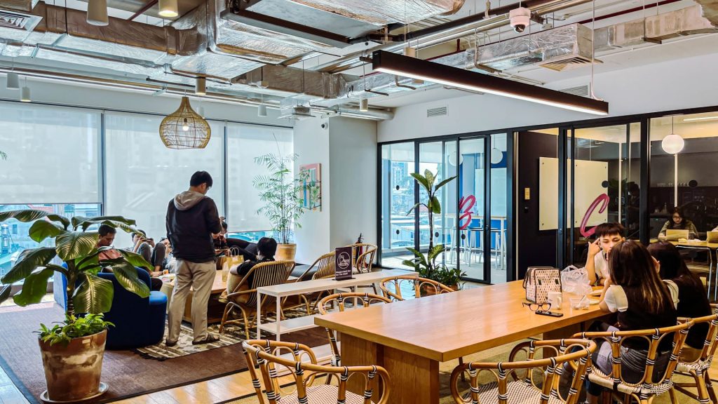 Two people chatting comfortably on sofas in a casual breakout lounge.