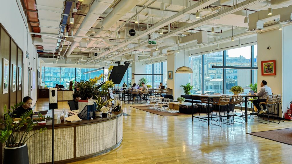 A person checking in at the reception desk or working in a cafe-style area.