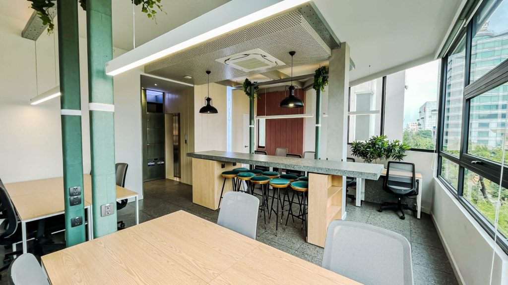 Row of ergonomic desks and office chairs in a workspace.