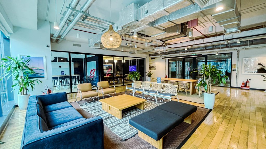 A coworking lounge area featuring potted plants and integrated greenery.