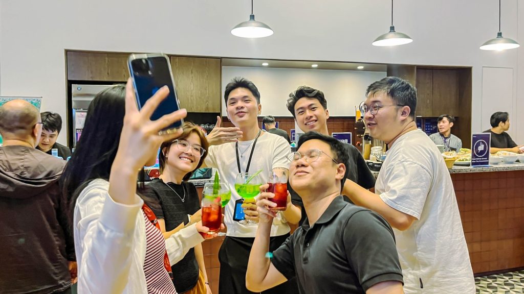An evening social gathering in the pantry area with members holding drinks.
