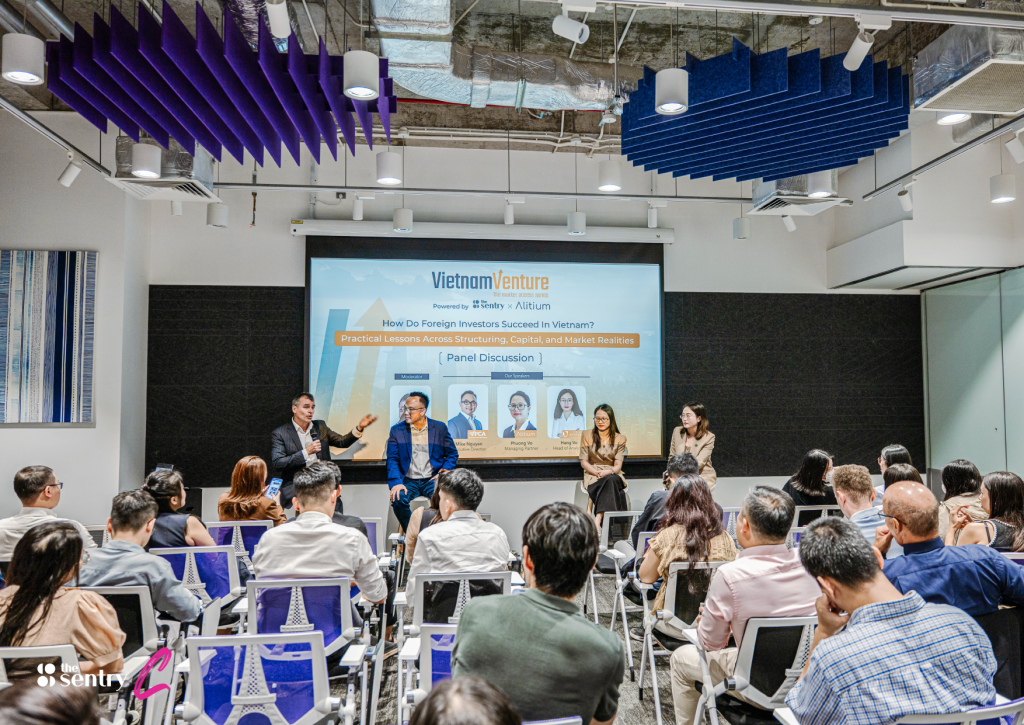 A speaker presenting to an audience in a tech-equipped seminar room.