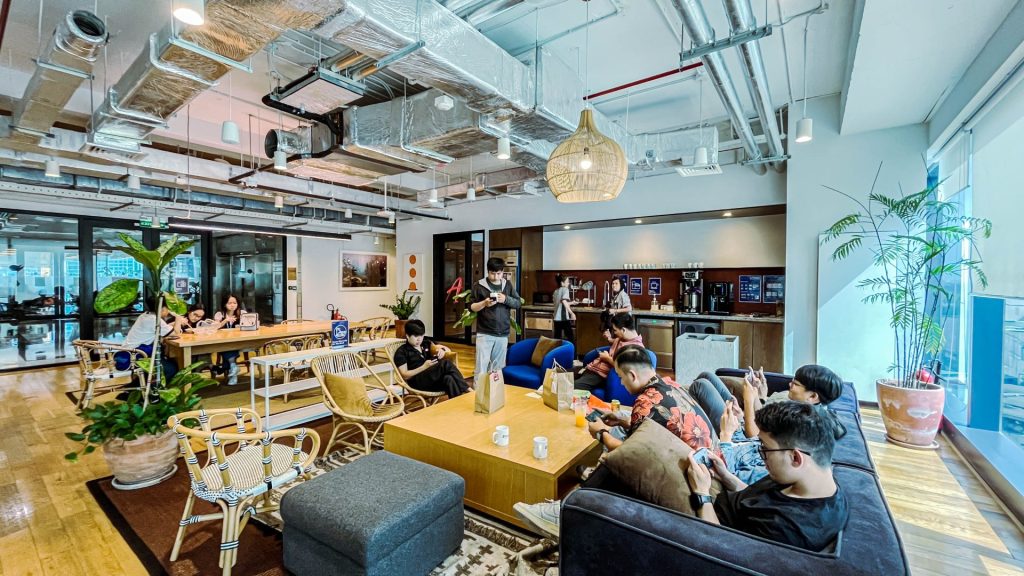 A group of colleagues standing and collaborating in a casual breakout space.