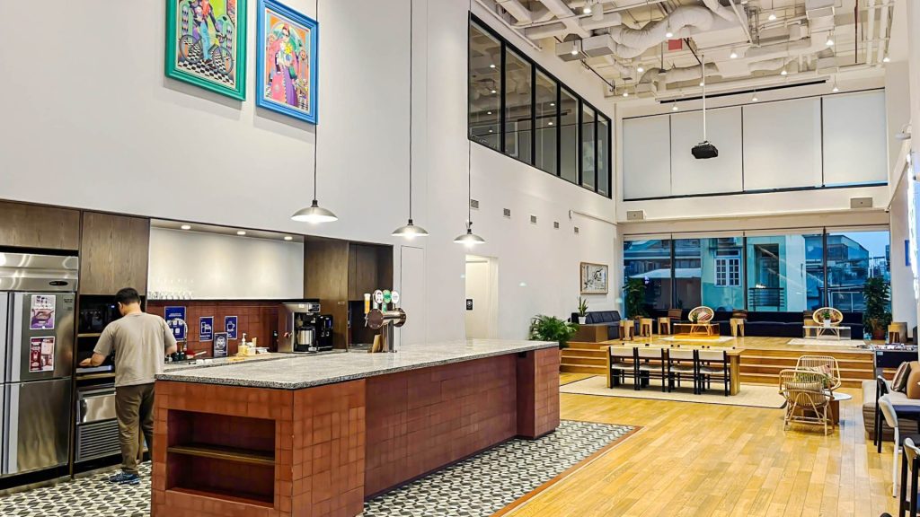 A group of professionals talking over coffee in a bright, modern pantry.