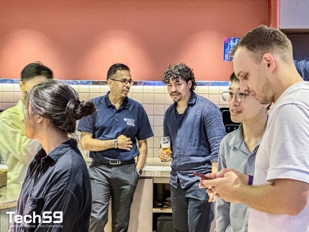 Two professionals casually chatting and smiling while getting coffee in a modern communal kitchen area.