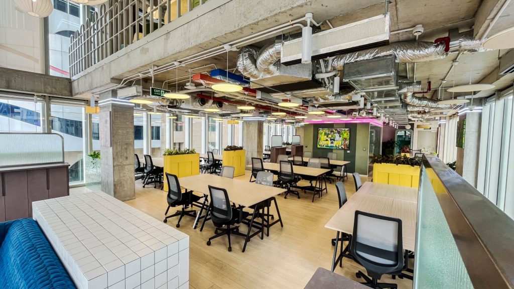 An eco-friendly office design featuring plenty of indoor plants, natural wood textures, and soft lighting.