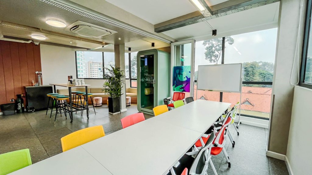 A professional glass-walled meeting room with a large table and modern presentation screen.
