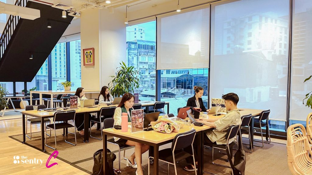 Professionals from different companies chatting casually in a coworking common area