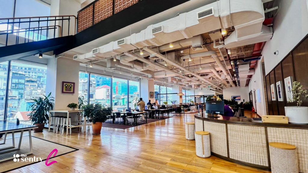 A clean, well-lit coworking floor with a mix of hot desks and collaborative seating