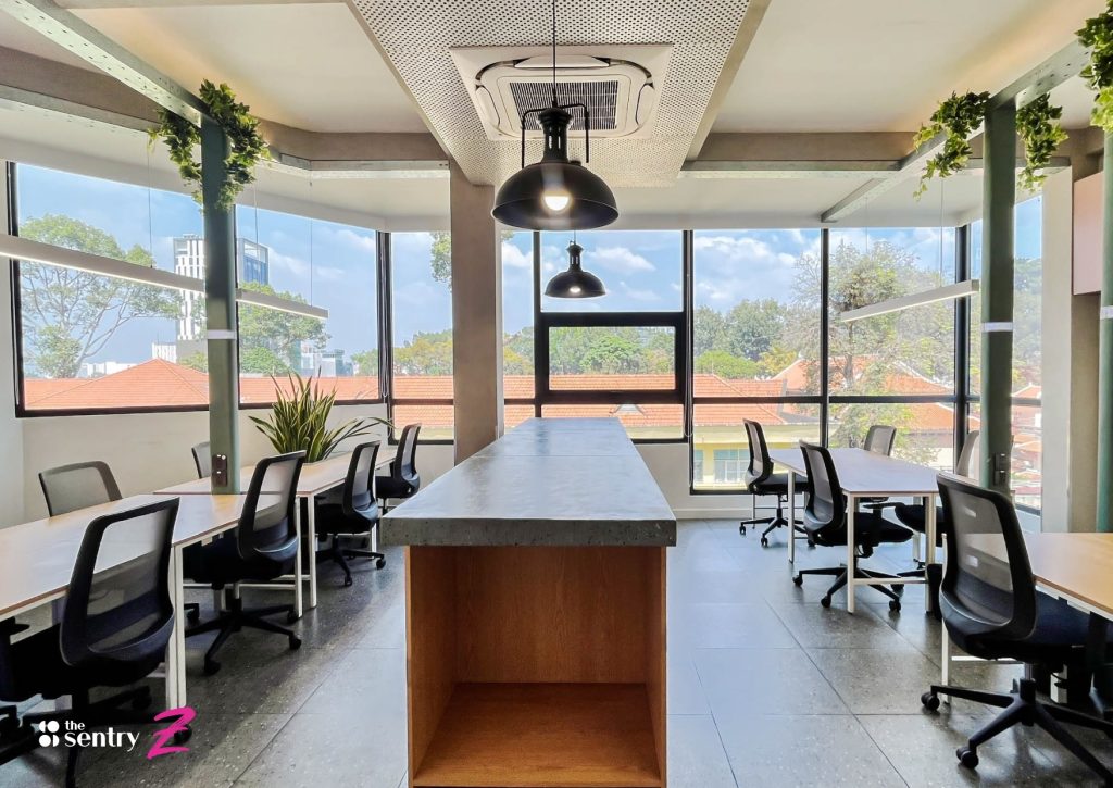 Sun-filled interior of The Sentry workspace featuring plants and floor-to-ceiling windows