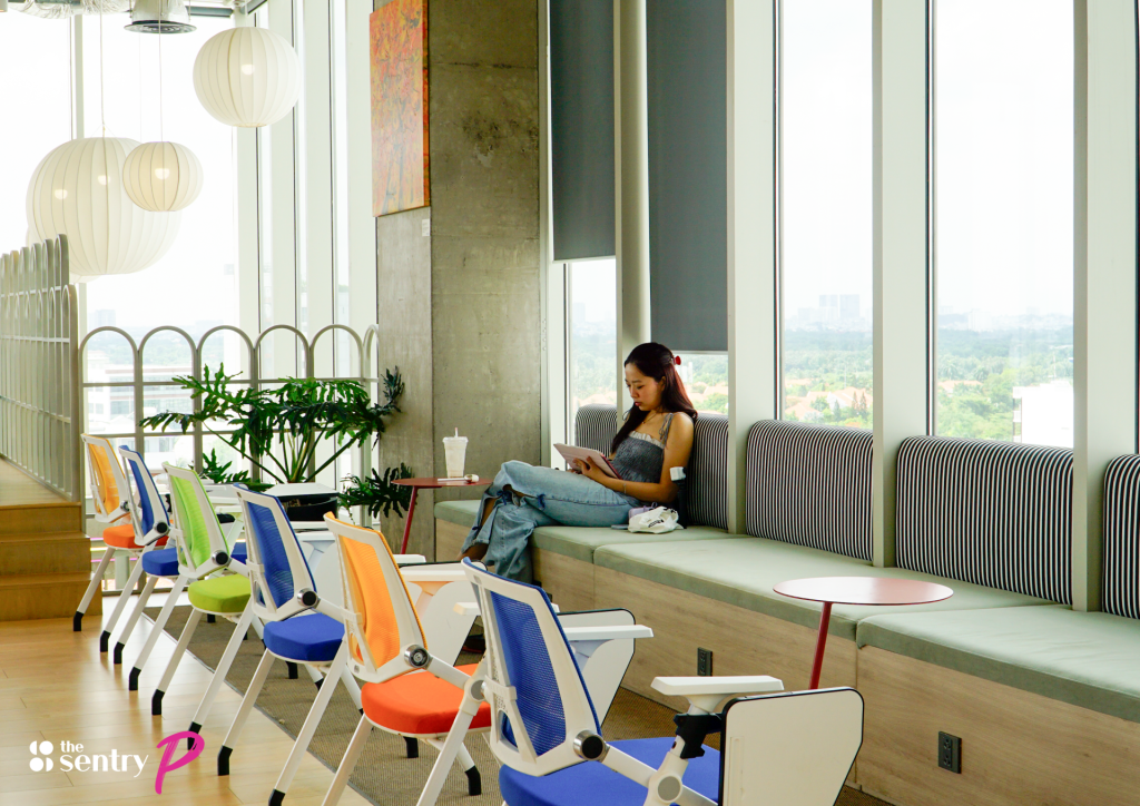 A business traveler working comfortably on a laptop in a stylish coworking lounge area. Caption: Regional managers and consultants visiting for short projects may qualify for a work permit exemption if their total working days remain under 90 per calendar year.