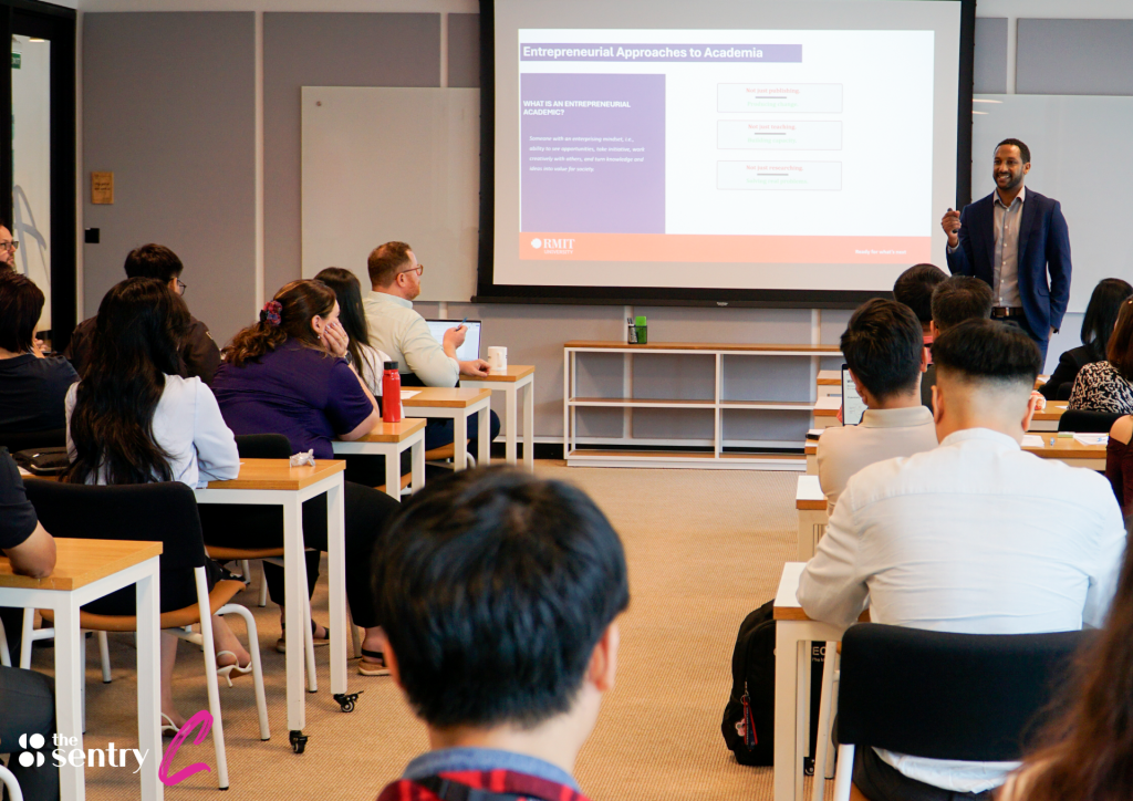 Team members holding a meeting around a conference table in a modern glass meeting room.