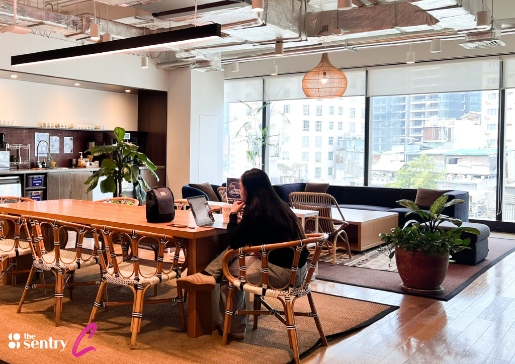 Freelancers working independently in a spacious, modern communal workspace.