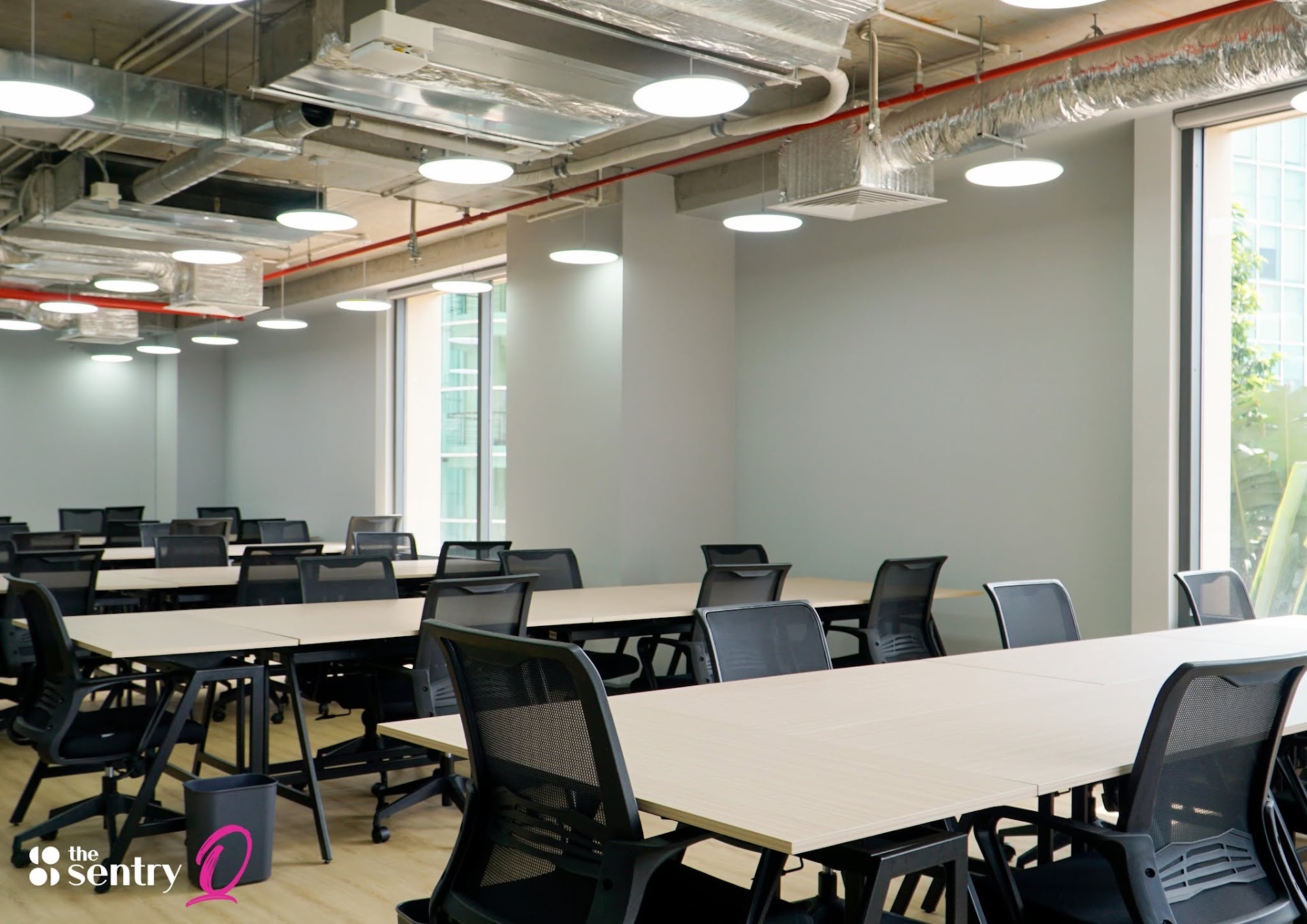 Glass-walled private office suite with furnished desks at The Sentry