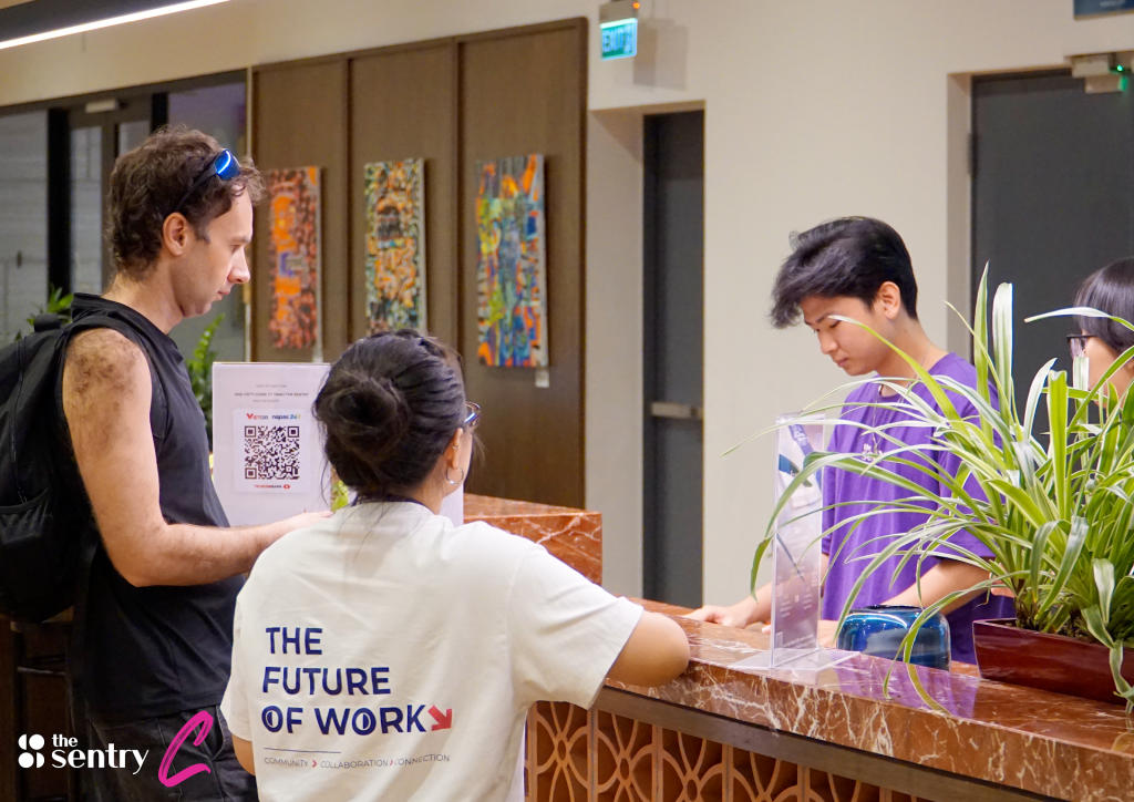 Receptionist greeting a visitor at the front desk of The Sentry